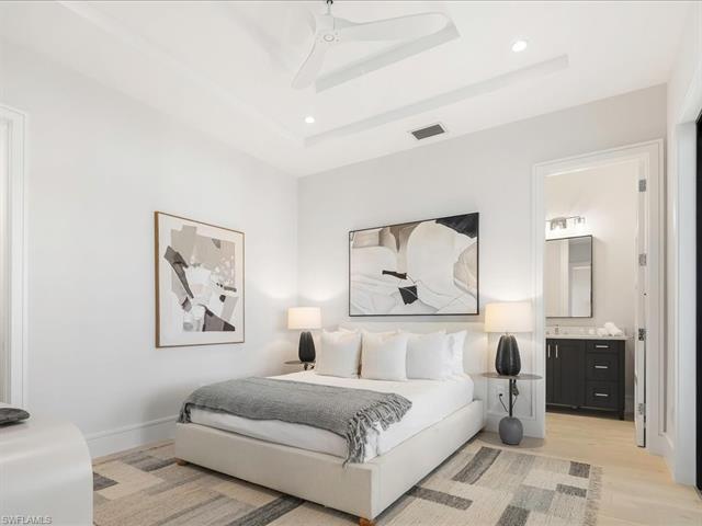 Bedroom featuring recessed lighting, baseboards, a raised ceiling, light wood-style floors, and visible vents