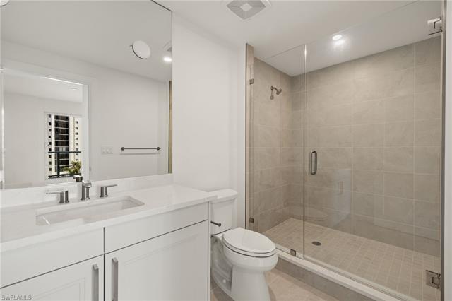 Bathroom featuring vanity, a stall shower, tile patterned flooring, and toilet