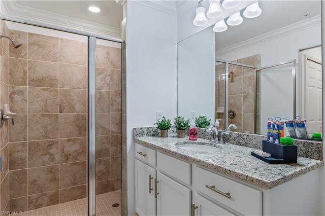 Bathroom with an enclosed shower, crown molding, and oversized vanity