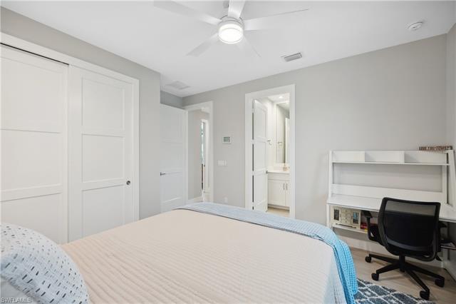 Bedroom featuring connected bathroom, a closet, wood-type flooring, and ceiling fan