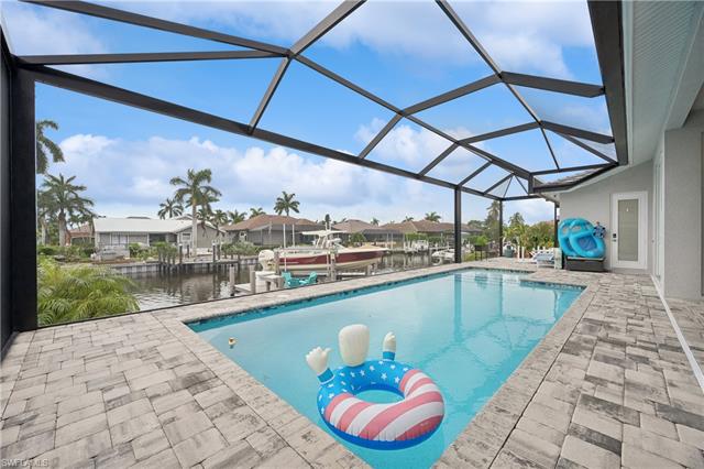 View of swimming pool featuring a boat dock, a lanai, and a patio area