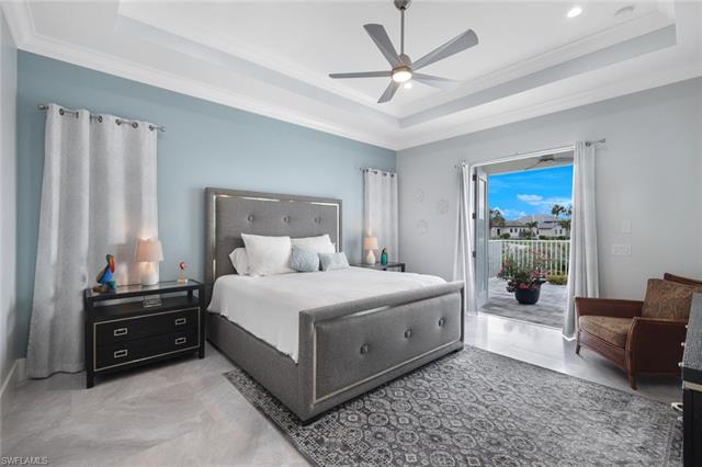 Bedroom with ceiling fan, a tray ceiling, crown molding, access to outside, and light tile patterned floors