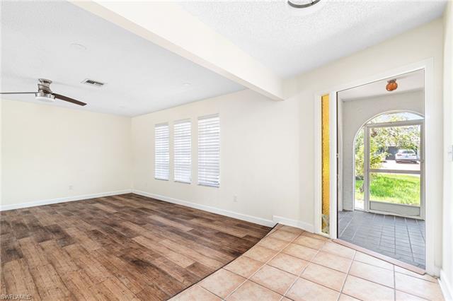 Tiled foyer with beamed ceiling, a textured ceiling, and ceiling fan