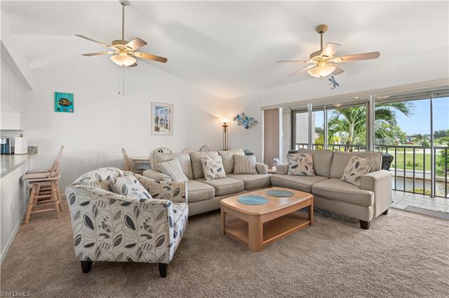 Carpeted living room featuring lofted ceiling and ceiling fan