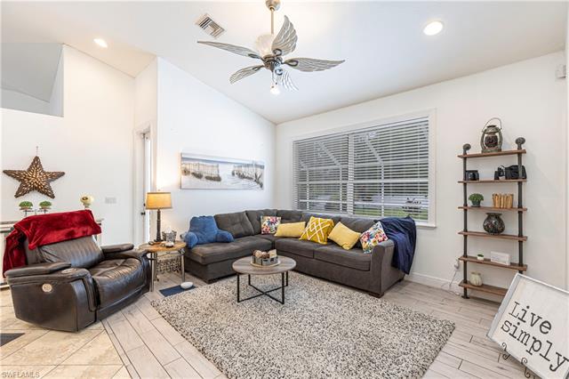 Living room featuring ceiling fan, light hardwood / wood-style floors, and lofted ceiling
