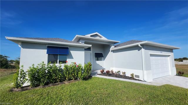View of front of property featuring a garage and a front lawn