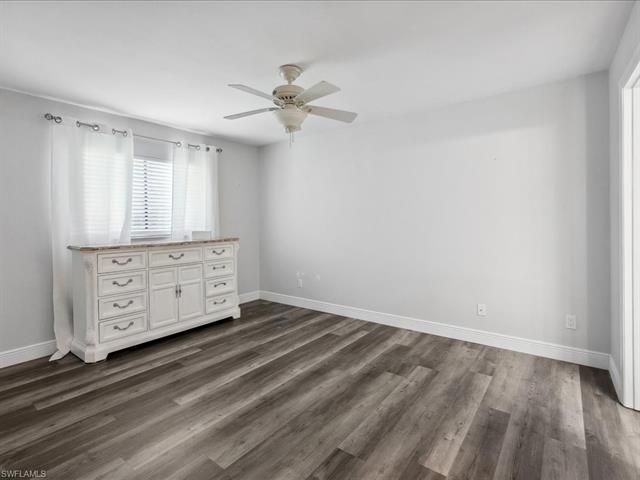 Unfurnished bedroom featuring ceiling fan and dark hardwood / wood-style floors