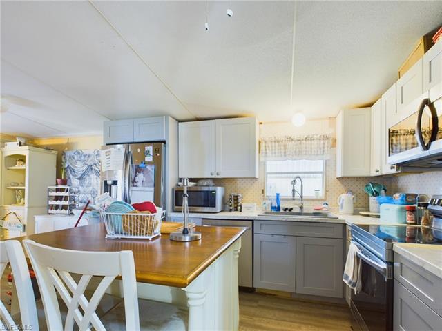 Kitchen featuring gray cabinetry, appliances with stainless steel finishes, tasteful backsplash, sink, and light wood-type flooring