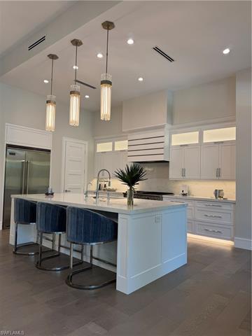 Kitchen with visible vents, dark wood-type flooring, white cabinetry, fridge, and decorative backsplash