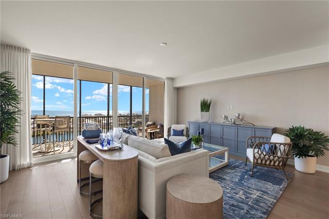 Living area featuring a water view, baseboards, floor to ceiling windows, and wood finished floors