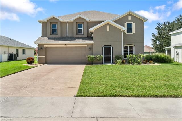 View of front of property featuring central AC, a garage, and a front lawn