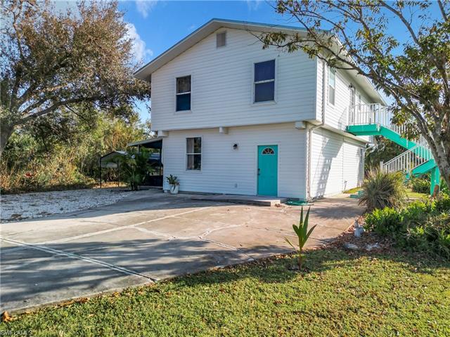 Rear view of property with a yard and a carport