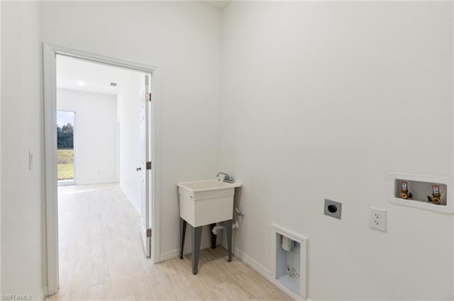 Washroom featuring hookup for an electric dryer, washer hookup, and light wood-type flooring