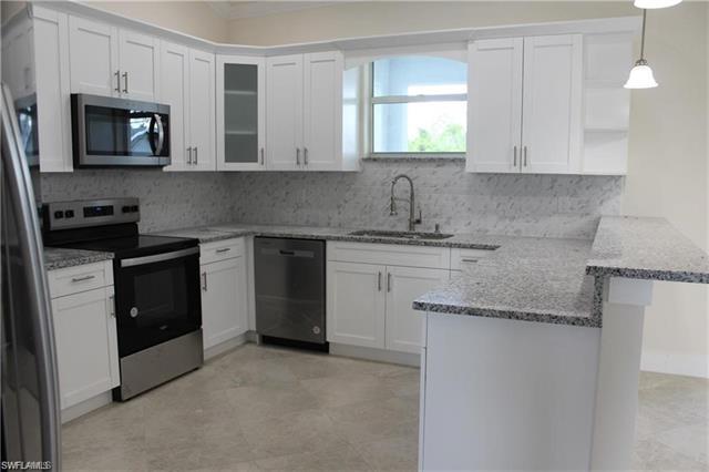 Kitchen with sink, kitchen peninsula, stainless steel appliances, pendant lighting, and white cabinets