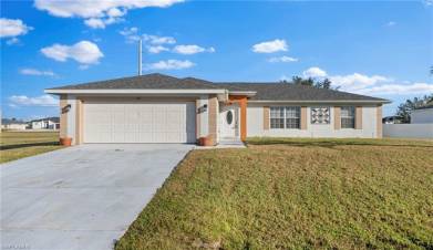 Single story home with a garage and a front lawn