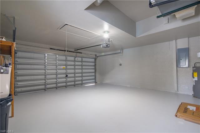Garage featuring electric panel and a garage door opener