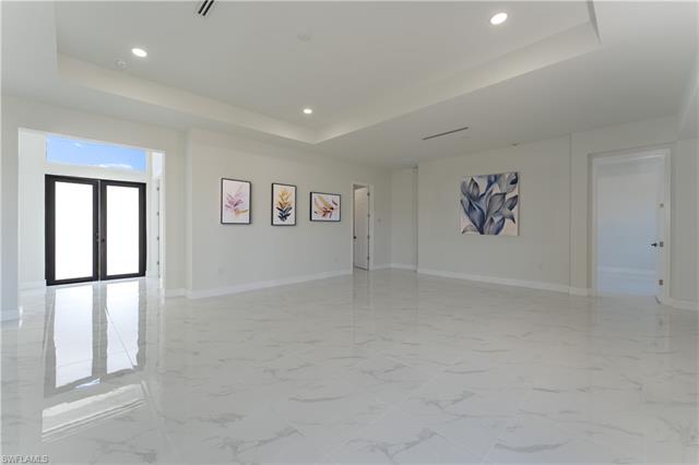 Empty room featuring a raised ceiling and french doors