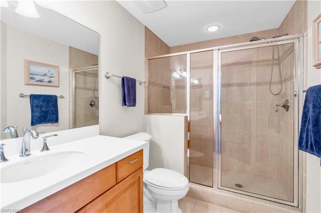 Bathroom featuring vanity, toilet, walk in shower, and tile patterned flooring