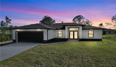 View of front of property with an attached garage, concrete driveway, french doors, stucco siding, and a front lawn
