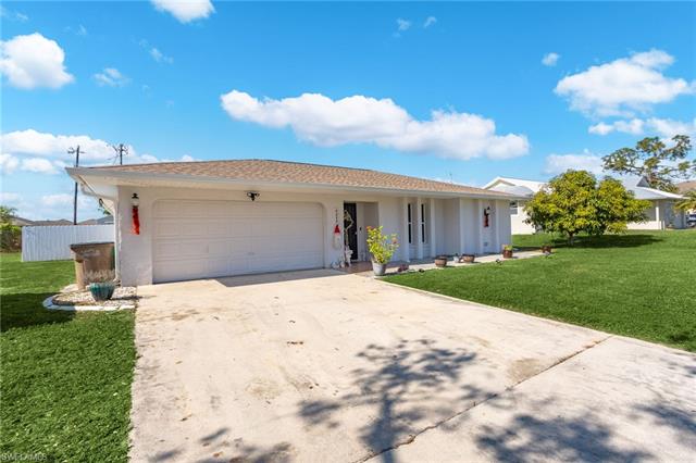 Ranch-style house with a front yard and a garage
