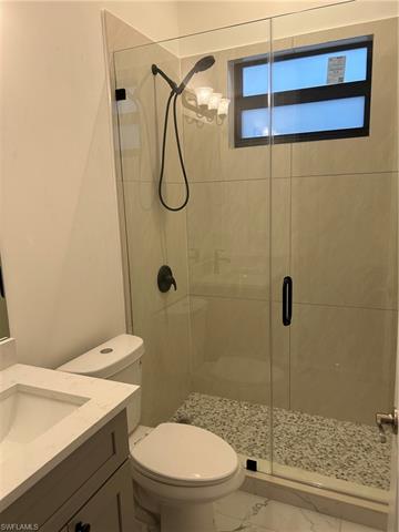 Bathroom featuring vanity, toilet, and walk in shower