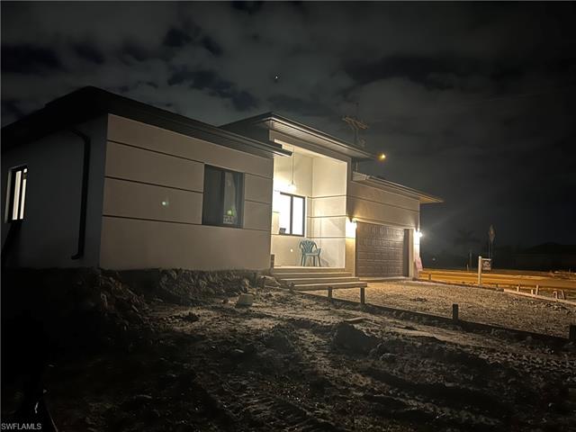 Property exterior at night with a garage