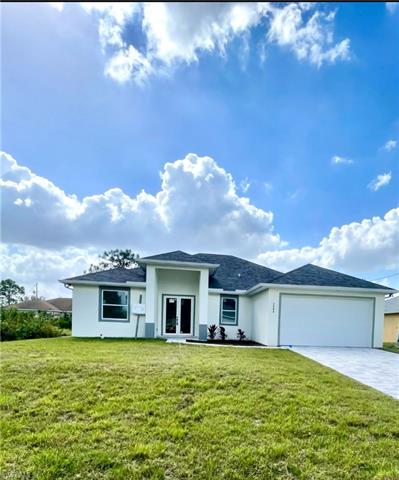 View of front of property featuring a front lawn, a garage, and french doors