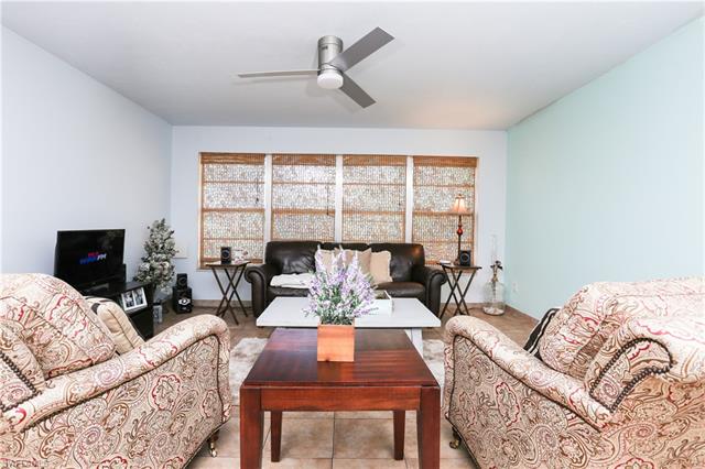 Living room with ceiling fan and light tile patterned floors