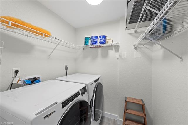Laundry room featuring hardwood / wood-style floors and washing machine and clothes dryer