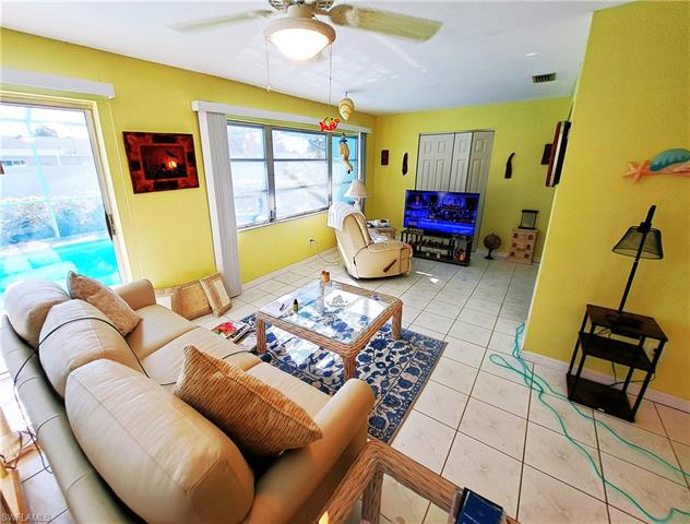 Living area featuring a wealth of natural light, visible vents, light tile patterned flooring, and a ceiling fan