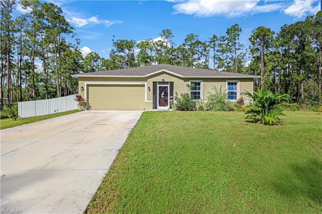 Single story home with a garage and a front lawn