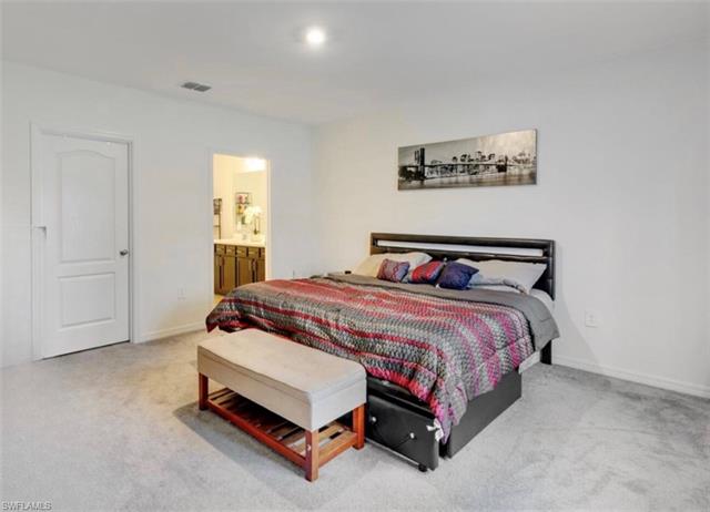 Bedroom with ensuite bathroom and carpet flooring