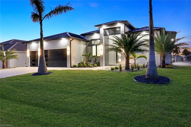 View of front of home with a yard and a garage