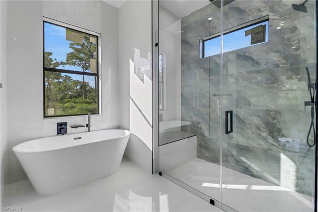 Bathroom with a wealth of natural light, shower with separate bathtub, and tile patterned floors