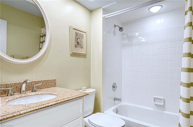 Full bathroom with toilet, shower / tub combo with curtain, and vanity