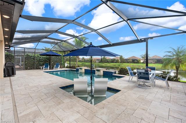 Outdoor pool featuring a patio, area for grilling, a lanai, and a hot tub