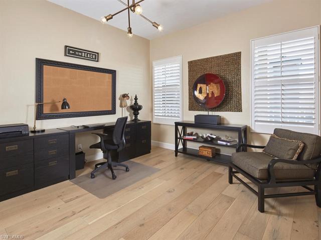 Spacious office or den with wood flooring and plantation shutters.