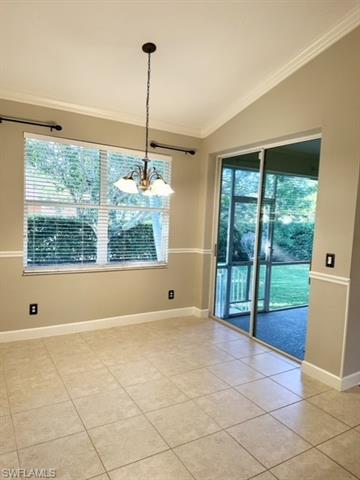 Unfurnished dining area with a wealth of natural light, crown molding, vaulted ceiling, and light tile patterned floors