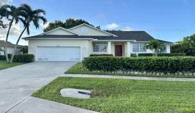 Single story home featuring a garage and a front lawn