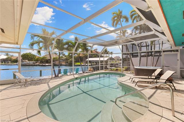 Outdoor pool with a lanai, a water view, a jacuzzi, and a patio