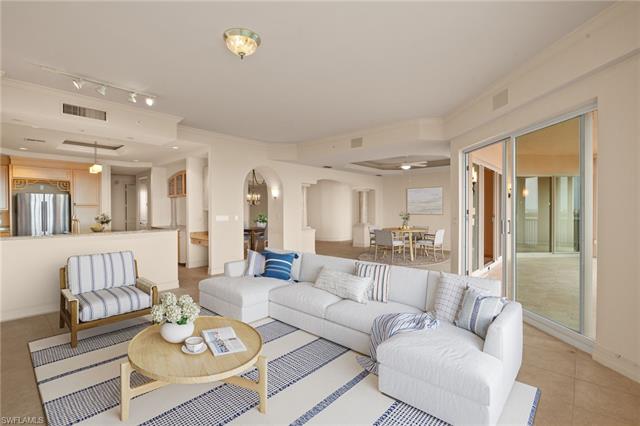 Virtually Staged. Living area featuring visible vents, arched walkways, crown molding, and light tile patterned flooring