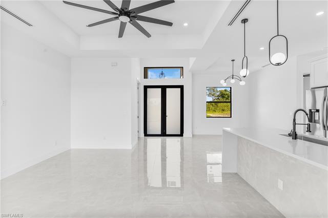 Entrance foyer with ceiling fan, a tray ceiling, visible vents, and recessed lighting