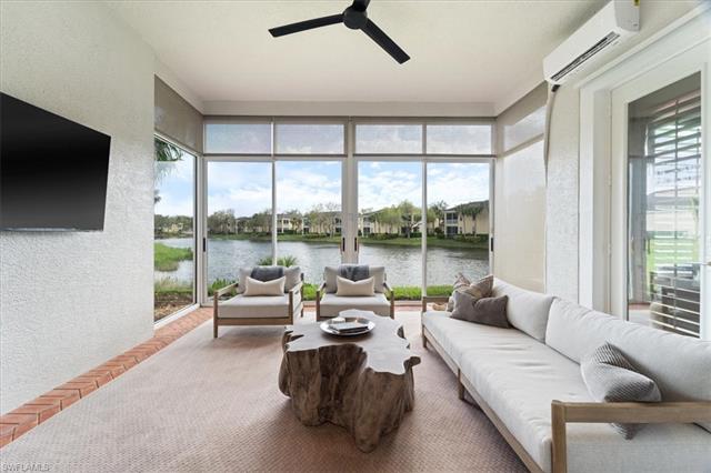 Sunroom / solarium featuring an AC wall unit, a water view, and a healthy amount of sunlight