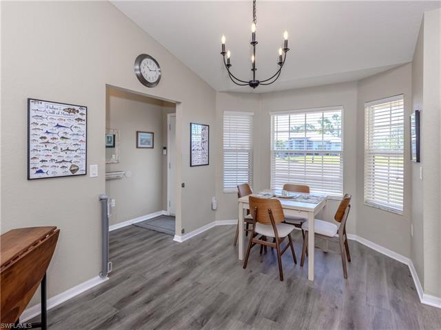 Dining area featuring vaulted ceiling, baseboards, wood finished floors, and an inviting chandelier