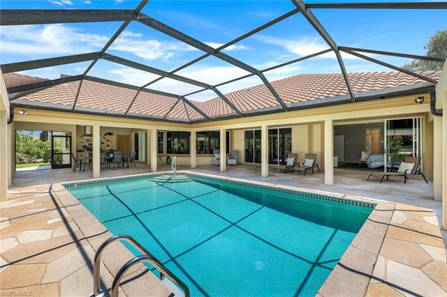 Outdoor pool featuring glass enclosure and a patio area