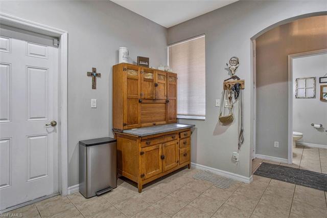 Bathroom featuring toilet, baseboards, and tile patterned floors