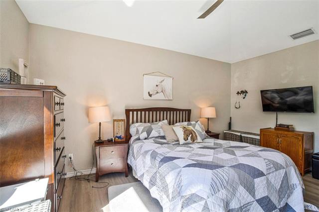 Bedroom featuring a ceiling fan, light wood-type flooring, visible vents, and baseboards