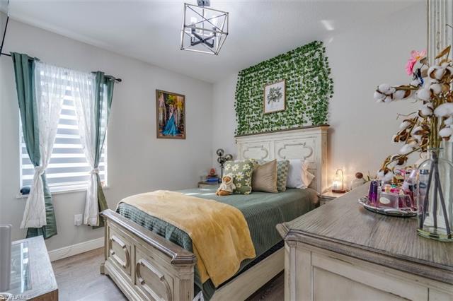 Bedroom featuring light hardwood / wood-style floors and a notable chandelier