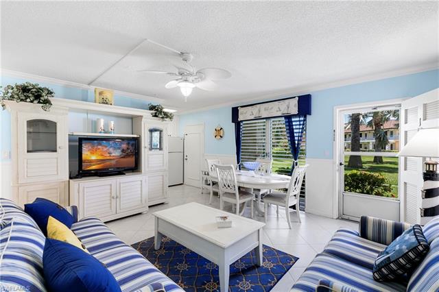 Tiled living room featuring ceiling fan, a textured ceiling, and ornamental molding