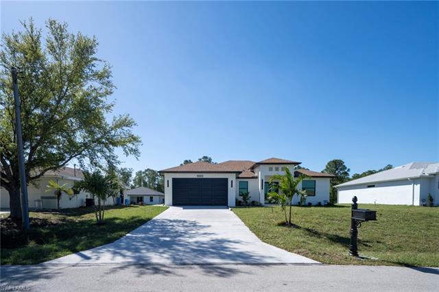 View of front of property with an attached garage, driveway, and a front yard